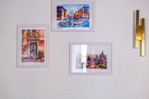 four framed pictures on a white wall at Elegantis Trevi Suite Apartment - Just 50m from Trevi Fountain in Rome