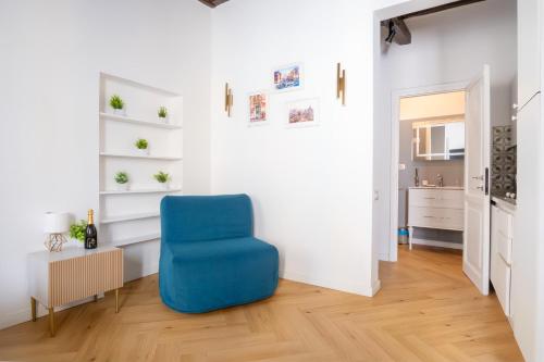 a blue chair in a room with a white wall at Elegantis Trevi Suite Apartment - Just 50m from Trevi Fountain in Rome