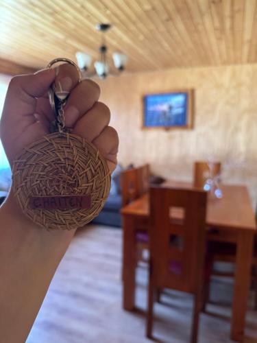 a person holding up a keychain with a house at "Cabaña A y M" in Chaitén