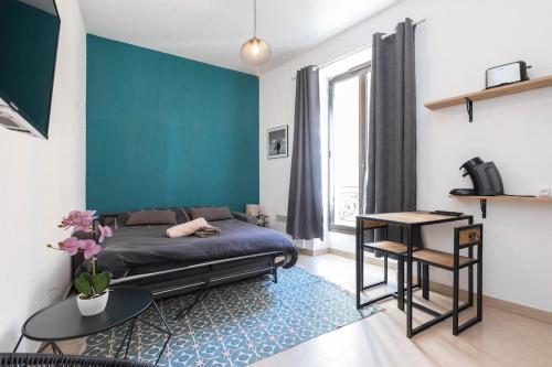 une chambre avec un lit et un mur bleu dans l'établissement Superbe studio Nice hyper centre immeuble standing, à Nice