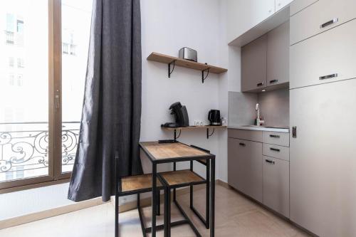 - une cuisine avec deux tabourets et une table dans l'établissement Superbe studio Nice hyper centre immeuble standing, à Nice