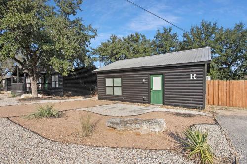 a black shed with a green door in a yard at Starlight Horizon 2 Cabins Hot Tub & Pool - Pet-Friendly Texas Hill Country Stay Near Canyon Lake Sleeps 12, Stargazing, Group Getaway in Canyon Lake
