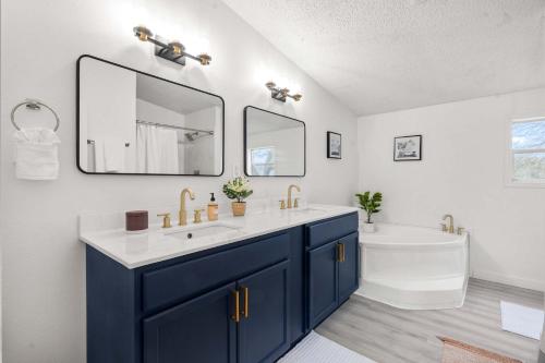 a bathroom with a sink and a tub and a mirror at Starlight Horizon 2 Cabins Hot Tub & Pool - Pet-Friendly Texas Hill Country Stay Near Canyon Lake Sleeps 12, Stargazing, Group Getaway in Canyon Lake