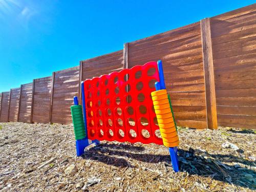 a colorful lego game in front of a fence at Starlight Horizon 2 Cabins Hot Tub & Pool - Pet-Friendly Texas Hill Country Stay Near Canyon Lake Sleeps 12, Stargazing, Group Getaway in Canyon Lake
