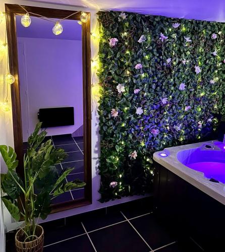 La salle de bains est pourvue d'un mur recouvert de fleurs. dans l'établissement Muraille du château avec jacuzzi, à Nemours