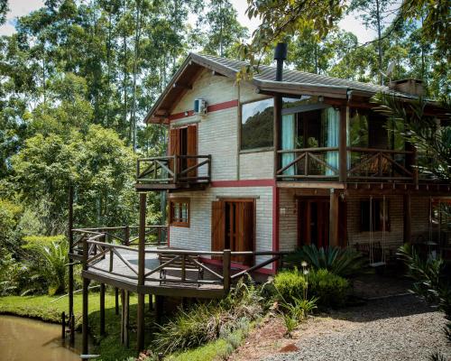 a house with a wrap around porch and a wrap around deck at Refúgio Serra Grande in Três Coroas