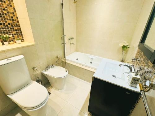 a bathroom with a toilet and a sink and a tub at Buenos Ayres Apartment in Buenos Aires