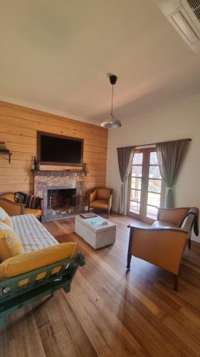 a living room with a couch and a fireplace at Myrtlebank Cottage Farmstay in Bundalaguah