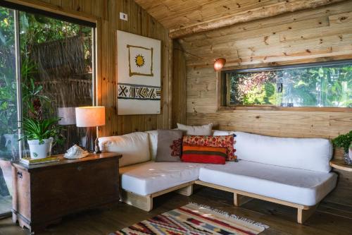 a living room with a white couch and a table at Casa Luz Paraty in Paraty