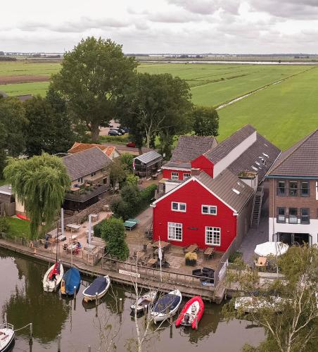 an aerial view of a red house and boats on the water at Schippershuis in Elahuizen