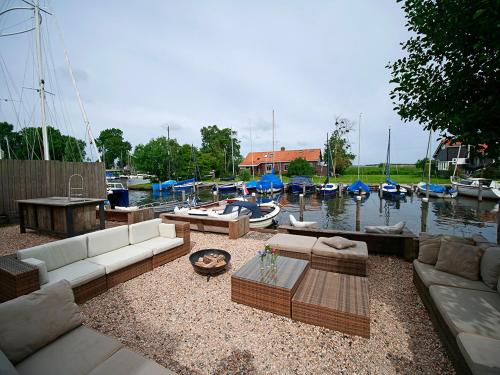 a living room with couches and boats in the water at Schippershuis in Elahuizen