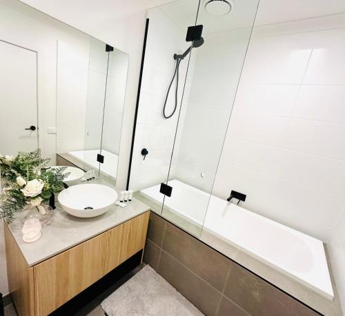 a bathroom with a sink and a bath tub at Williamstown Townhouse in Williamstown