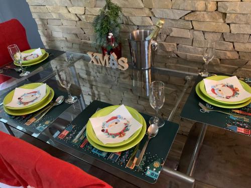 a dining table with plates and glasses on it at Baladise Apartman in Balatonvilágos