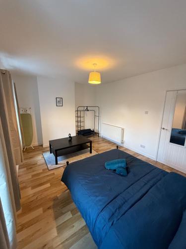 a bedroom with a blue bed and a piano at Charming 3-Bedroom house in Cardiff