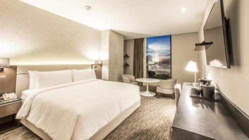 a hotel room with a white bed and a table at Four Points by Sheraton Puebla in Puebla
