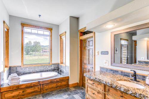 a bathroom with a tub and two sinks and a window at Spacious Afton Home Patio, Grill and Mountain Views in Afton