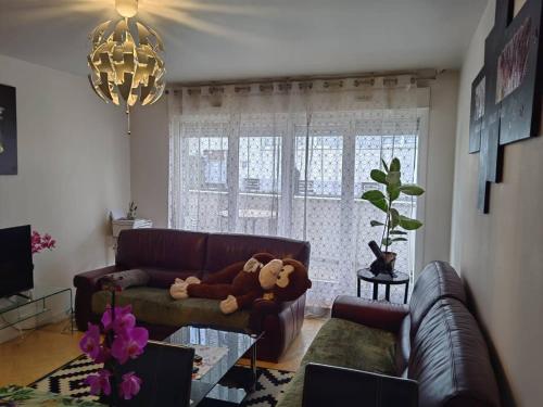 a teddy bear sitting on a couch in a living room at Les Lilas in Chantepie
