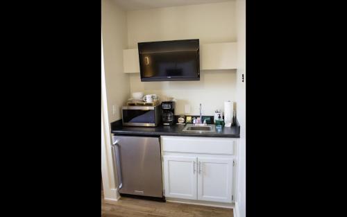 a small kitchen with a sink and a microwave at Leland House Suites of Durango in Durango