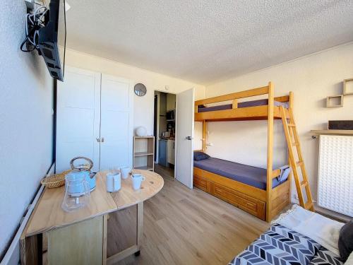 Cette petite chambre comprend des lits superposés et un bureau. dans l'établissement Résidence Chaviere - Studio agréable · Ski au pieds · Balcon MAE-2784, aux Menuires