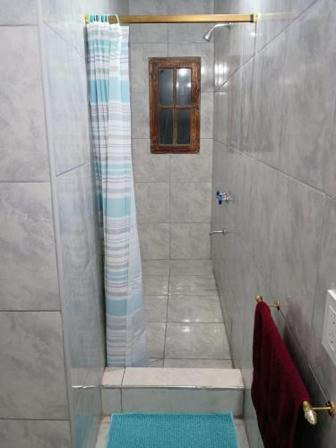 a shower with a glass door in a bathroom at La casita de Sanber in San Bernardo