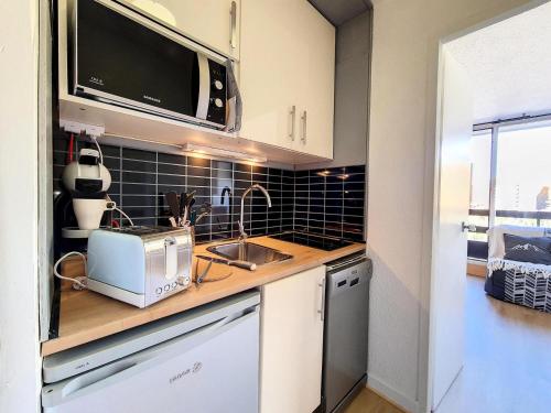 La cuisine est équipée d'un évier et d'un grille-pain. dans l'établissement Résidence Chaviere - Studio agréable · Ski au pieds · Balcon MAE-2784, aux Menuires