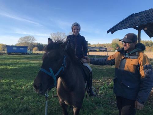a man is standing next to a person on a horse at Domek Walentinki in Rogacze