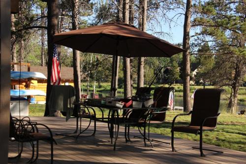 a table and chairs under an umbrella on a deck at Mt. Bachelor & Sun River Get Away in Bend