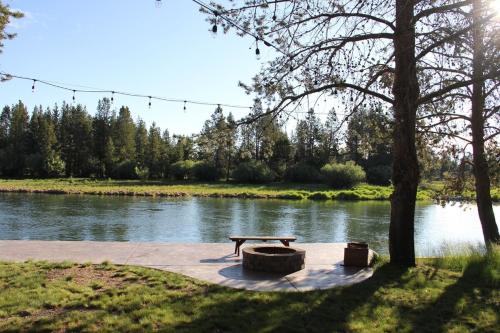 a picnic table sitting next to a river at Mt. Bachelor & Sun River Get Away in Bend