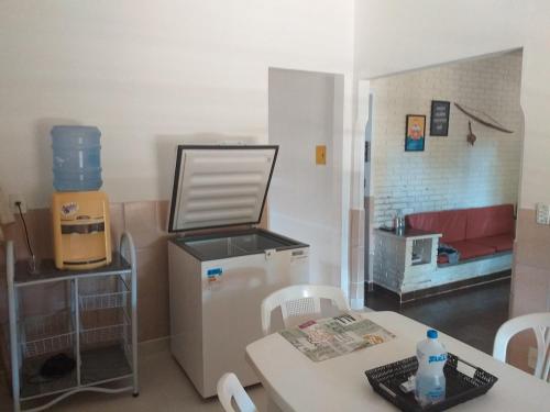 cocina con nevera, mesa y sofá en Casa Praia Grande, en Nova Almeida