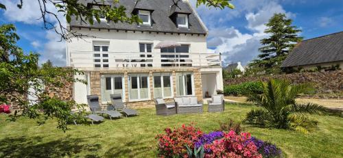 a house with chairs and flowers in the yard at Escapade Bretonne - Binic, proche plages et vieux port in Binic-Etables-sur-Mer