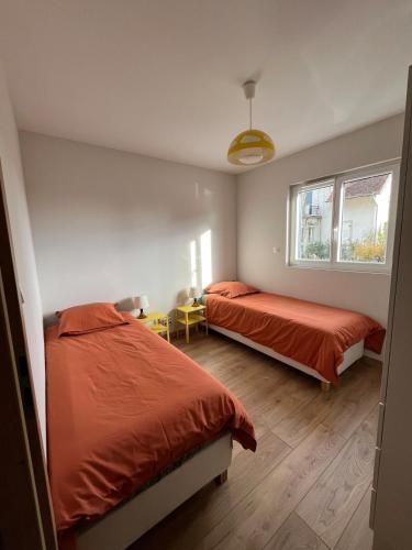 une chambre avec deux lits et une fenêtre dans l'établissement Gîte Cigogne et Sanglier, à Châtenois