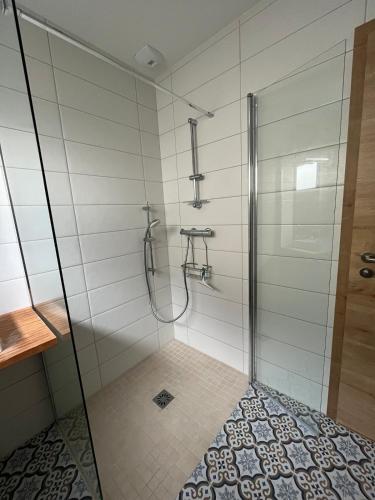 une salle de bain avec une douche avec une porte vitrée dans l'établissement Gîte Cigogne et Sanglier, à Châtenois