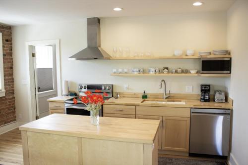 a kitchen with a vase of flowers on a counter at Leland House Suites of Durango in Durango