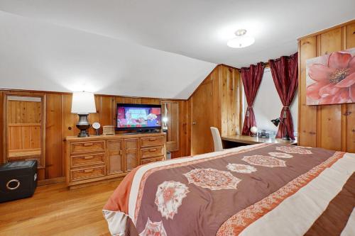 a bedroom with a bed and a flat screen tv at Super Cute & Cool Home with 65Inch TV 2Baths 4 Bedrooms 2King Beds BBQ Grill Fenced Backyard in Ferndale