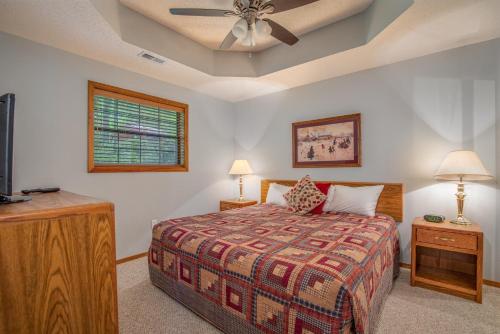 Un dormitorio con una cama y un ventilador de techo. en 2BR Village At Indian Point 1004 near SDC-Free Tickets Daily up to $500, en Branson