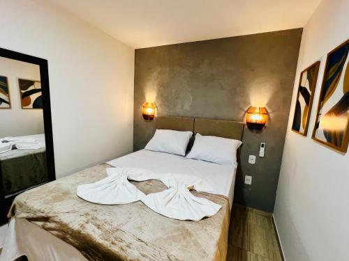 a bed in a room with two towels on it at Flats da Garça - Praia de Garça Torta em Maceió in Maceió