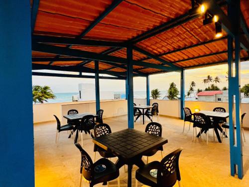 a patio with tables and chairs and the ocean at Flats da Garça - Praia de Garça Torta em Maceió in Maceió