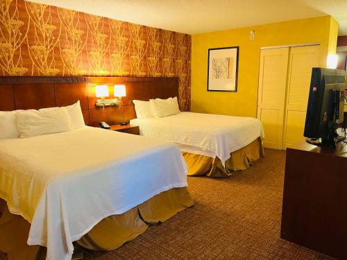 a hotel room with two beds and a flat screen tv at Sonesta Essential Junction City in Junction City