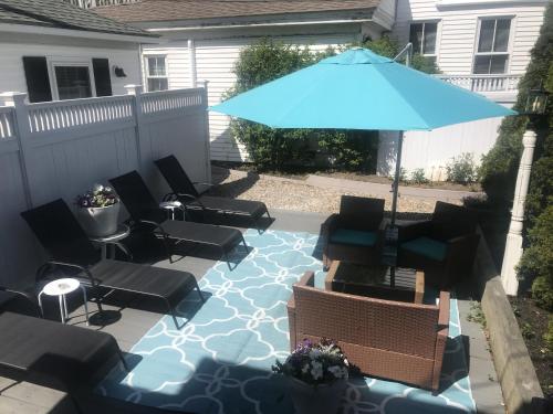 a patio with chairs and a blue umbrella at The John Randall House in Provincetown