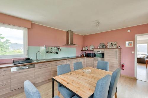 une cuisine avec une table en bois et des chaises bleues dans l'établissement Escapade Bretonne - Binic, proche plages et vieux port, à Binic