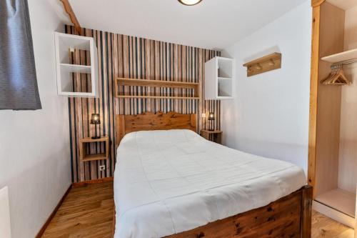 une chambre avec un lit en bois avec des draps blancs dans l'établissement Résidence Les Hauts De Preclaux - Appartement deux pièces au coeur des Orres 1800 MAE-4481, aux Orres