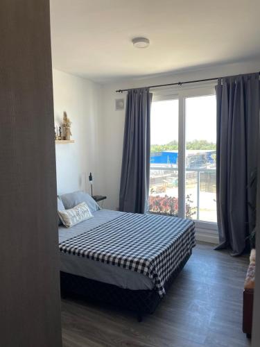 a bedroom with a bed and a large window at Roma in Belén de Escobar