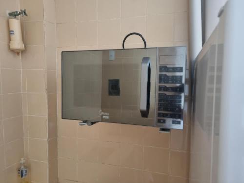 ガラパリにあるApartamento Centro Guarapariのバスルームの壁に電子レンジ