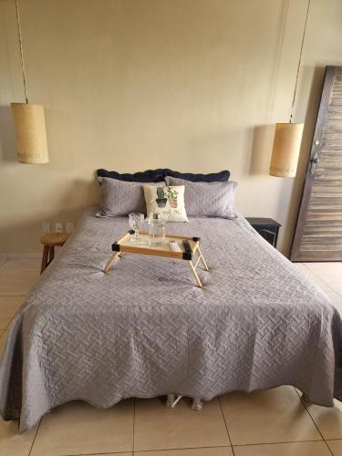un lit avec un plateau avec des verres dessus dans l'établissement Pitaia casa para temporada, à Aracaju