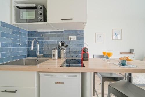 une cuisine avec un comptoir en bois et un évier dans l'établissement Le Cli’Chic, à Clichy