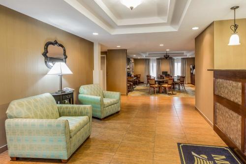 a living room with chairs and a dining room at MainStay Suites Grand Island in Grand Island