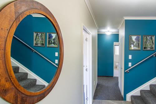 a mirror in a hallway with blue walls and stairs at Comfortable Spacious Home, Close to Beach in Kaikoura
