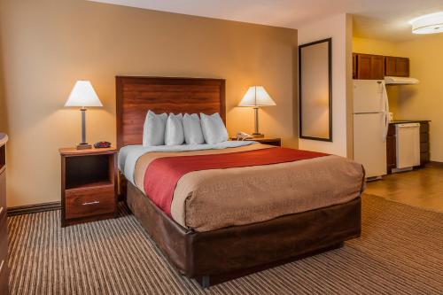 a large bed in a hotel room with two lamps at MainStay Suites Grand Island in Grand Island