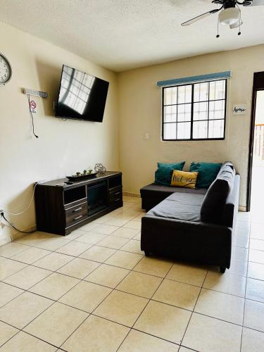 a living room with a couch and a flat screen tv at Rosarito beachside apartment in Rosarito Beach