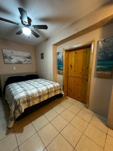 a bedroom with a bed and a ceiling fan at Rosarito beachside apartment in Rosarito Beach